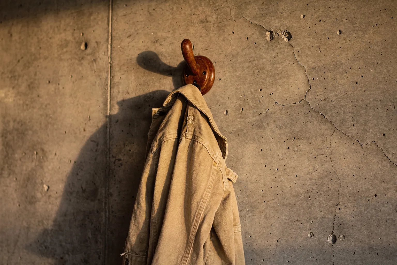 Gantungan jaket kayu di dinding beton studio